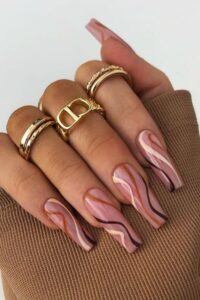 Brown swirls on pink nails